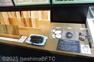 触れる展示物の一例。写真にはさまざまな木のサンプルや種類、色が違う丸い小石や炭などが置かれている。