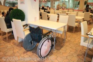 テーブルの前に置かれた車いすのようす。車いすの方も食事がしやすい高さであることが良く分かる。