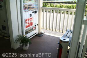 自動販売機の前に喫煙のための灰皿とベンチあり