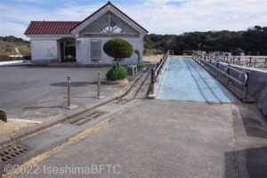 左手に駐車場、右手にスロープが見える。駐車場からスロープ前までに4㎝ほどの段差がある。