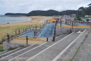 道路から浜へ降りる大きなスロープを道路の上から見下ろしたようす。
スロープはつづら折りになっていて、かなり長い。