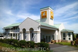 建物外観のようす。全景　緑の屋根に黄色い看板