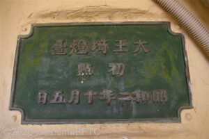 灯台の壁にはめ込まれた銅板。大王崎灯台　初点　　昭和2年10月5日と刻まれている。
古い看板のため、右側から横書きされている。