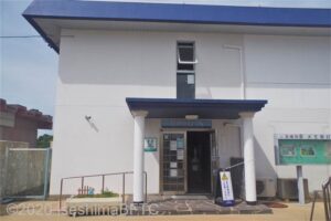 「大王埼灯台ミュージアム」外観のようす。2階建ての四角い白い建物。屋根は青色。