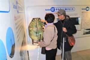 視覚障害者のカップルが展示物をさわっているようす。