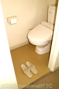トイレのようす　右手に便器　壁面にトイレットペーパー　入り口にスリッパあり