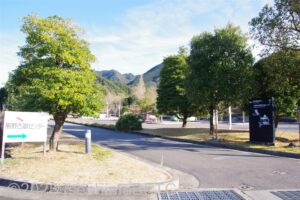 駐車場の入口のようす。両脇には大きな木々が植えられている。