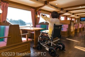 1階からの景色を写真に撮る車いす使用者