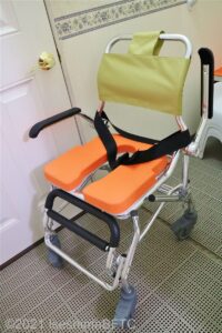 貸出用シャワーキャリー。シャワーキャリーとは浴室で使う車いすのこと。座面はオレンジ色。