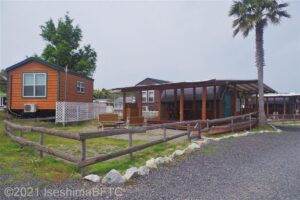 オレゴンと呼ばれるバリアフリー対応のキャビン。木製の平屋建て。専用の庭は、簡易の柵で囲われている。庭には芝生が植えられている。