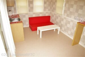 キャビン室内のようす。赤いソファーと白いテーブルが置かれている。