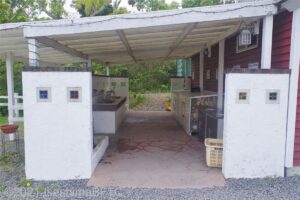管理棟向かい側の分別ゴミ置き場のようす。屋外だが白い屋根がかかっている。