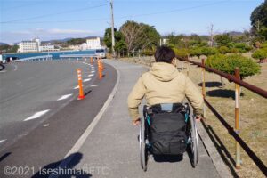 駐車場から桟橋まで歩いている車いすの男性のようす。
