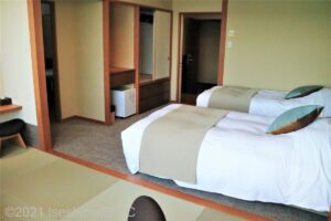 窓側から室内を見た様子。ツインベッドにはうぐいす色のベッドライナーが敷かれている。