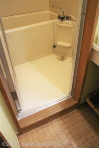 浴室への入口。段差あり。浴室は一般家庭にあるようなユニットタイプ。少し狭い。