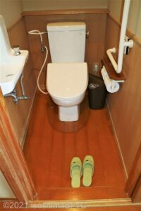 脱衣所にある洋式トイレのようす。便器に向かって右側にL型手すりあり。