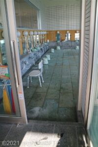 室内浴室側の入口幅80センチ、引戸。引戸下段差10センチ。写真には扉のようすと、その向こうに洗い場が見える。