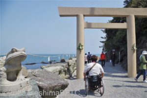 参道を進む車いす使用者と参道途中の鳥居