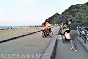 堤防へのスロープを上がる車いす使用者