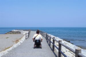 突堤の先へ向かう車いす使用者