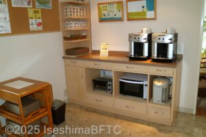 棚の上にコーヒーメーカー、棚の下にはポットとオーブントースター、電子レンジ