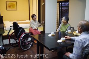 特別室　和室の畳へ移乗して、テーブルにいる家族と談笑している車いす使用者