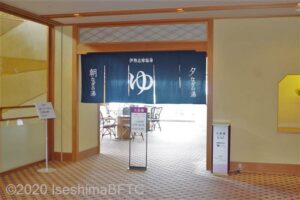 2階　待合サロン「憩」の入口のようす。青い暖簾がかかっている。