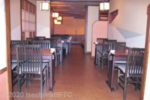 館内レストラン、麺処「そよご」の店内のようす。黒塗りで木製のイスとテーブルが置かれている。