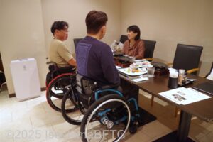 レストランで食事する車いすの男性2人