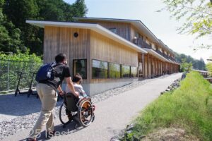 10.「サンセバスチャン通り」の坂を介助してもらって上がる車いすの女性