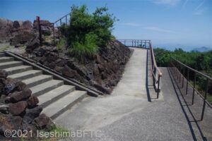 先の写真の右側の道を進んだようす。中央には展望足湯に続くスロープがある。スロープには手すりがついている。