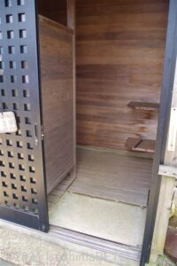 更衣室のようす。小さな小屋になっていて、室内は1畳程度の広さ。木製の棚が付いている。