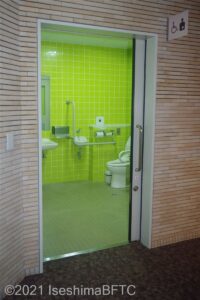 館内車いす対応トイレの入り口　左から右の引き戸　トイレ内は湿式