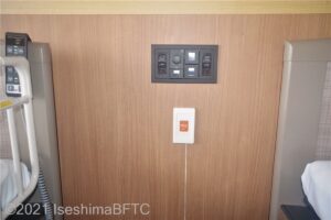 ベッドとベッドの間に室内の電気のスイッチ　その下には緊急ボタン