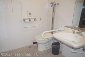 トイレのようす便器に座って右壁にトイレットペーパーホルダー　その右横に洗浄ボタンその隣に緊急ボタン　トイレットパーパーホルダーの上壁に温水洗浄便座の操作パネル