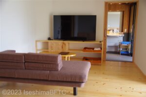 ユニバーサルデザインルーム　ソファと大型テレビ、右側に洗面脱衣室の入口