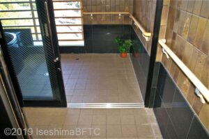 半露天風呂への入口幅92センチ、3枚引戸。段差なし。壁に横手すりあり。浴槽は半露天のみで、内風呂はない。