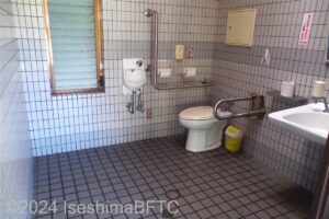 入口から見て右奥に、よこ置きに便器がある。入口からみて右手前に洗面台