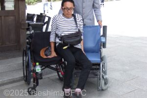 自分の車いすから参拝専用車いすに移乗するようす