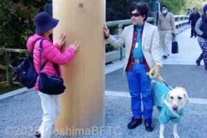 宇治橋の鳥居に触れて太さを確かめる視覚障害者