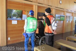休憩所内の写真展示を見る車いす使用者