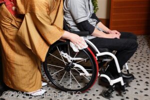スタッフが車いす使用者のタイヤを拭いているところ