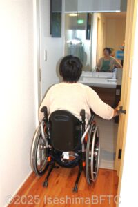 車いす対応トイレへ入る車いすの女性