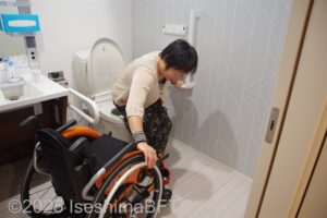 便器へ乗り移る車いすの女性