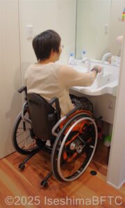 洗面台を使用する車いすの女性