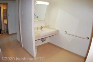 207号室の洗面所のようす。洗面台の下が広くあいていて、車いすでも膝が入るようになっている。