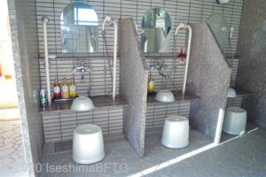 洗い場のようす。洗い場どうしの間には仕切りがある。写真は立ち上がり用の縦型手すりがついている洗い場のようす。