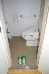 脱衣所にあるトイレのようす。便器に向かって左側の壁には横型のI字手すりが付いている。