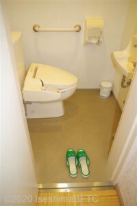 脱衣所にあるトイレのようす。便器に向かって右側の壁には横型のI字手すりが付いている。