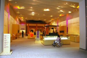 展示室Ⅰ「文字からわかる斎宮」の展示ケースの前に車いすの女性がいる写真